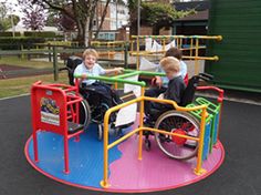 two children in wheelchairs playing on a playground