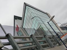 a large building with many windows next to a metal fence and street light on a cloudy day