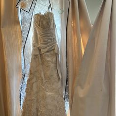 wedding gowns are displayed in front of white drapes