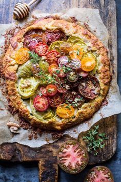 a pizza with tomatoes, cucumbers and other toppings on top of it