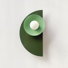 a green bowl with a white ball in it