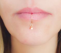 a close up of a woman's nose with a gold nose ring on it