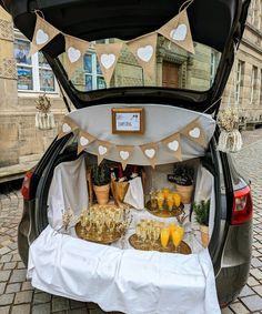 the trunk of a car is filled with food and decorations for an outdoor wedding or bridal party