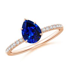 an oval blue sapphire and diamond ring on a white background with the top stone in yellow gold