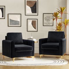 two black chairs sitting on top of a rug in a living room next to paintings