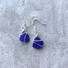 Genuine cobalt blue sea glass earrings that are handmade and wrapped with tarnish resistant silver plated wire. The earring hooks are .925 sterling silver and hypoallergenic. It is not recommended to wear while bathing or swimming.  For sea glass collectors, this rare color dates between 1880-1950. One in 250 pieces of found sea glass will be cobalt blue! Approximate earring drop is .75". The earrings are light, easy to wear and will catch the sunshine beautifully! My jewelry is inspired by organic design, the beach and the ocean. Owning genuine sea glass jewelry is unique because each piece is one-of-a-kind. Jewelry is packaged for gifting and wrapped carefully for shipping.  Fall in love with sea glass! Gift Blue Fish Hook Earrings, Blue Fish Hook Earrings For Gift, Blue Sea Glass Nickel Free Earrings, Blue Sea Glass Nickel-free Earrings, Nickel-free Blue Sea Glass Earrings, Minimalist Blue Wire Wrapped Earrings, Blue Silver Plated Wire Earrings, Blue Silver-plated Wire Earrings, Handmade Blue Sea Glass Earrings