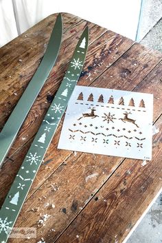 a pair of scissors sitting on top of a wooden table next to a paper snowflake