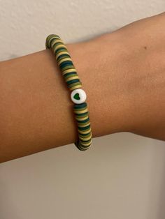 a woman's arm wearing a bracelet with an evil eye on the inside of it