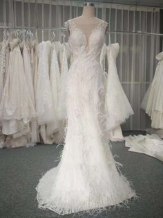 a white wedding dress on display in front of other dresses