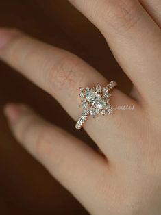 a woman's hand with a diamond ring on top of her finger and an engagement band