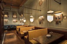 the interior of a restaurant with wooden tables and booths, framed pictures on the wall