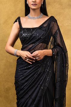 Editor's Note Black Chiffon Saree With Self Bead Work & Sequins Embroidery Color: Black Fabric: Chiffon Care: Dry Clean Only About the Designer Nitika Gujral’s journey with designing clothes started almost four decades back while she was still in high school and held her first exhibition for family and friends. Making clothes has been a part of her life ever since. Black Embellished Georgette Saree, Glamorous Black Embellished Saree, Embroidered Georgette Pre-draped Saree For Party, Glamorous Black Georgette Saree, Black Embellished Georgette Blouse, Black Embellished Party Wear Blouse Piece, Black Embellished Blouse For Party, Black Embellished Blouse Piece For Party, Black Embellished Party Blouse Piece