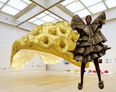 a woman standing in front of a giant golden object