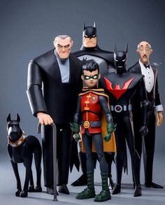 batman action figures are posed in front of an image of two men and a dog