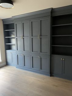 an empty living room with built in bookshelves