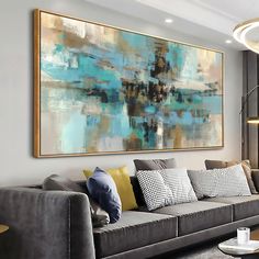 a living room filled with furniture and a large painting hanging on the wall above it