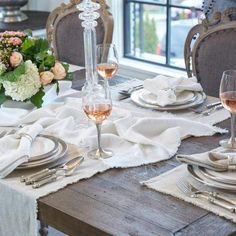 the table is set with silverware and wine glasses