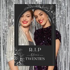 two women standing next to each other in front of silver tinsel curtain with the words r i p written on it