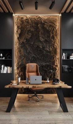 a desk with a laptop on it in front of a stone wall and wooden floors