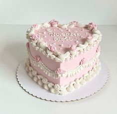 a pink heart shaped cake sitting on top of a white plate