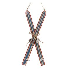 two skis tied together with twine and pine cones on the top, against a white background