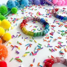 colorful bracelets and pom poms are scattered on the table with other items