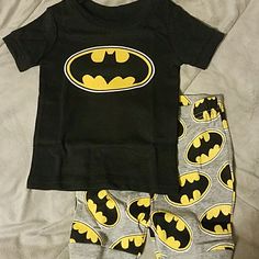 Short Sleeve Top In Black, With The Batman Sign And Shorts In Gray With All Over Batman Pattern. 12-18mo Black Cotton Playtime Sets, Black Cotton Bottoms For Playtime, Black Graphic Print Playwear Sets, Black Graphic Print Sets For Playwear, Black Letter Print Playwear Sets, Black Letter Print Sets For Playwear, Batman Pjs, Batman Pajama Pants, Batman Pajamas