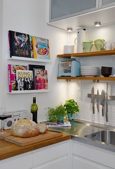 a kitchen with white cabinets and wooden counter tops