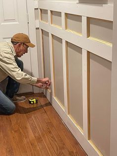 a man kneeling down on the floor with a drill and screwdriver in his hand