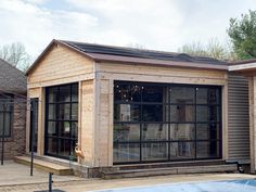 a small building with a pool in front of it and two windows on the side