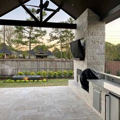 an outdoor kitchen with grills and cabinets