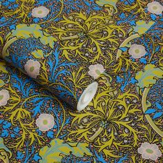 a blue and green floral print fabric with white buttons on the end of each piece