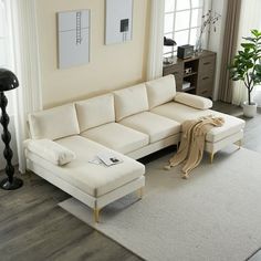 a living room with white furniture and large windows