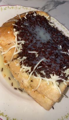 a piece of bread with chocolate sauce on it and cheese sprinkled over the top