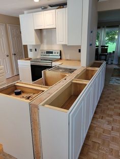 an unfinished kitchen with white cabinets and wood flooring in the process of remodeling