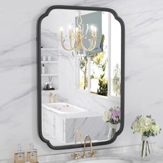 a bathroom with a sink, mirror and chandelier on the wall in front of it