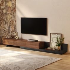 a flat screen tv sitting on top of a wooden entertainment center in a living room