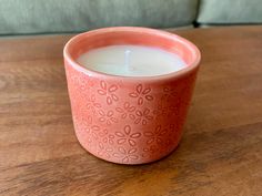 a pink candle sitting on top of a wooden table