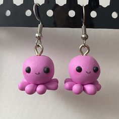 pink octopus earrings with black eyes hanging from hooks