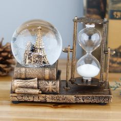 a snow globe with the eiffel tower in it and some other items around it