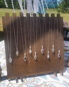 several necklaces are displayed on a wooden stand