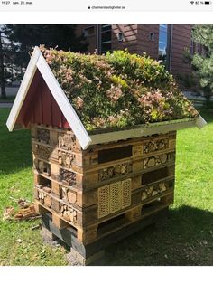 a beehive made out of wood with plants growing on it's roof