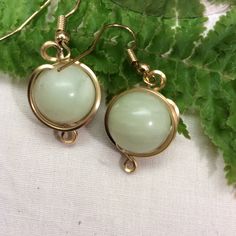 Lovely jade celadon green stone dangle earrings wrapped in 14K gold filled wire.  These are a very classic looking earring that coordinate with casual and dressy outfits.  The green is subtle and gentle and the gold adds highlights.      Niobian earwires are available on request and are great for those of us who are allergic to other metals!. The listing is for one pair of earrings.  Four pairs, plus, are available.  This would be a good present or to keep! Measurement:  Dangle approximately 1-1 Yellow Gold Jade Earrings, Gold Aventurine Earrings Gift, Aventurine Drop Earrings For Gift, Hypoallergenic Jade Drop Earrings, Gold Jade Wire Wrapped Jewelry, Gold Jade Earrings With Ear Wire, Jade Earrings With Ear Wire For May Birthstone, Hypoallergenic Dangle Jade Earrings, Gold Wire-wrapped Jade Earrings