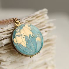 This personalised world map globe locket necklace has been carefully hand enamelled to turn the ocean into a beautiful, hand painted muted blue shade, with the continents a rich gold colour. We can personalise this locket for you, adding your photos inside and engraving the message of your choice on the back! This is a single sided locket, featuring the Eastern Hemisphere. If you would like the Western Hemisphere, it can be found here: This piece of handmade jewellery comes packaged in a nice re Blue Enamel Locket Jewelry, Engraved Round Pendant Jewelry As Souvenir, Engraved Round Pendant Jewelry For Souvenir, Turquoise Round Pendant Locket Jewelry, Turquoise Round Locket Jewelry, Blue Engraved Round Pendant Necklace, Round Turquoise Locket Jewelry, Blue Engraved Enamel Necklaces, Blue Enamel Engraved Necklace