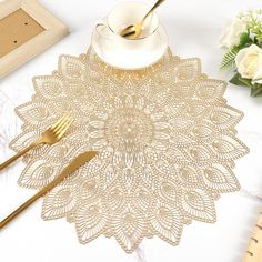 a place setting with gold colored utensils and flowers