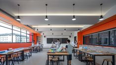 an orange and white classroom with students working on their desks