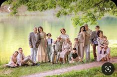 a group of people standing next to each other in front of a lake