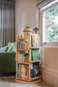 a bookshelf filled with lots of books next to a window