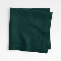 two dark green linen napkins sitting on top of each other