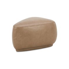 a tan leather ottoman sitting on top of a white floor